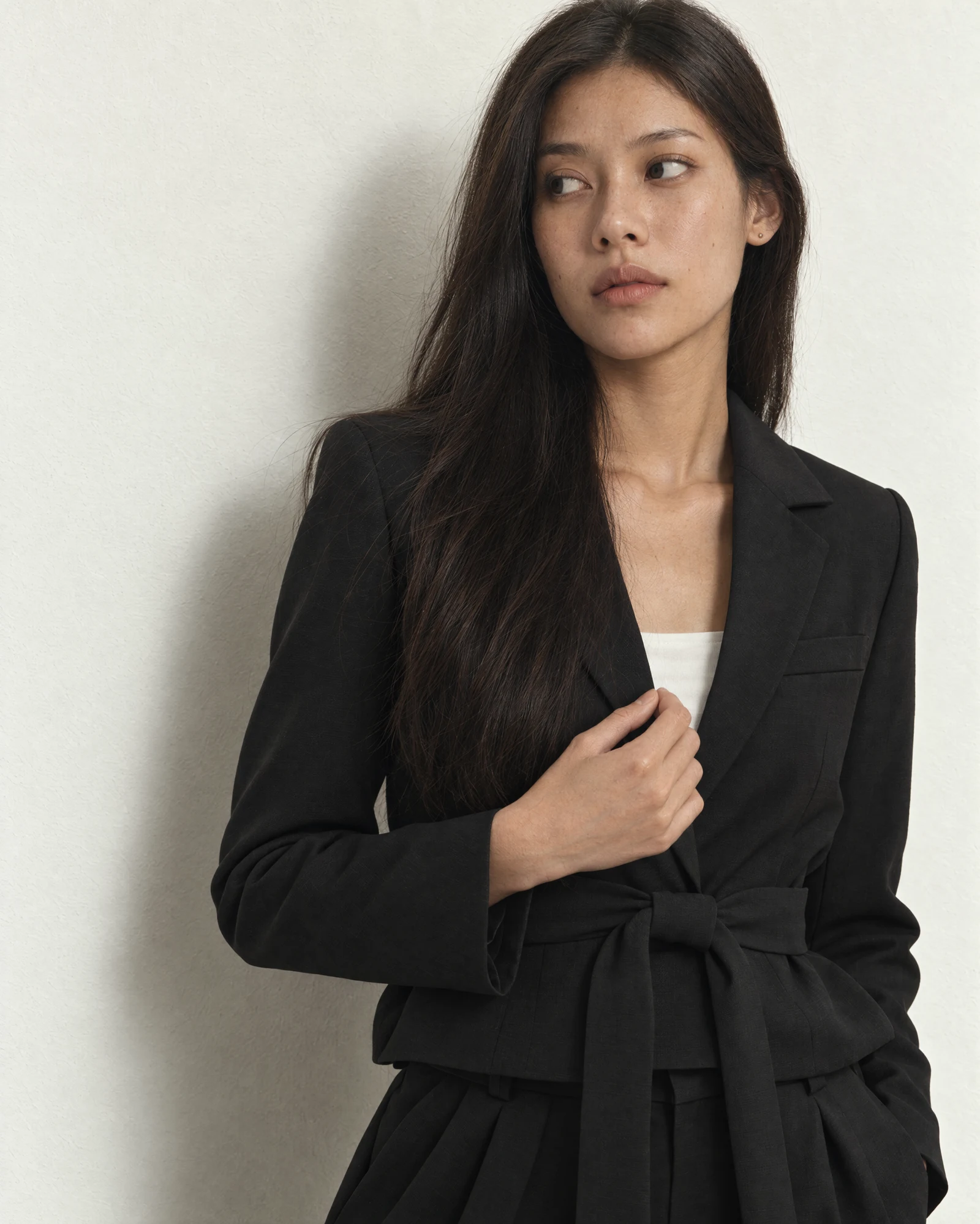 Perempuan memakai Black Charlotte Blazer dengan tali di pinggang